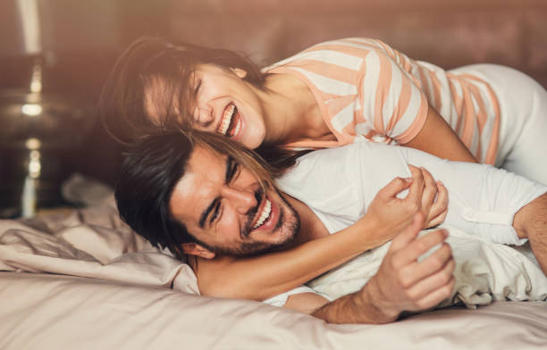 couple laughing bed